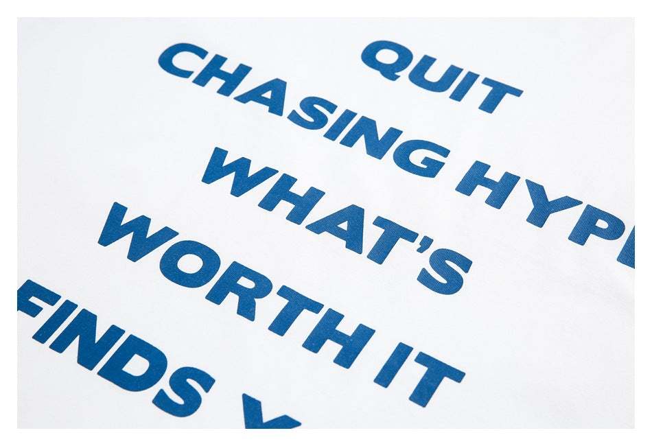 Close-up of bold blue lettering printed on white T-shirt fabric.