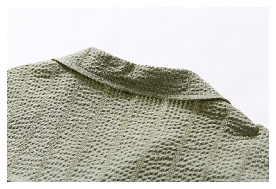 Close-up of the light olive shirt's folded collar and textured fabric.