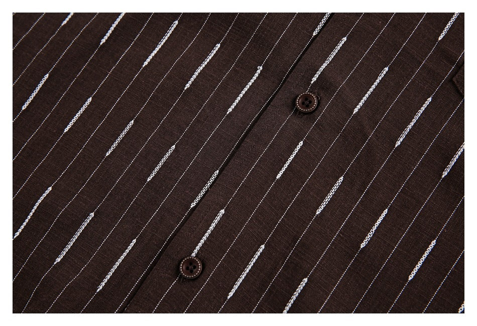 Close-up of two brown buttons on a placket over brown fabric with thin white dashed stripes.
