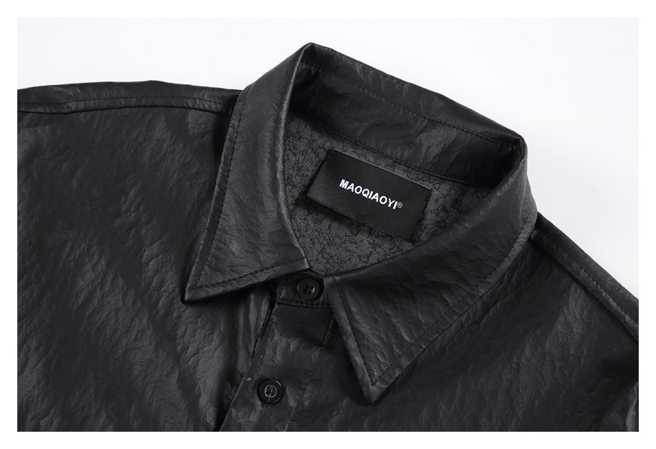 Close-up of a black textured shirt collar, top buttons, and inner neck label with white lettering.