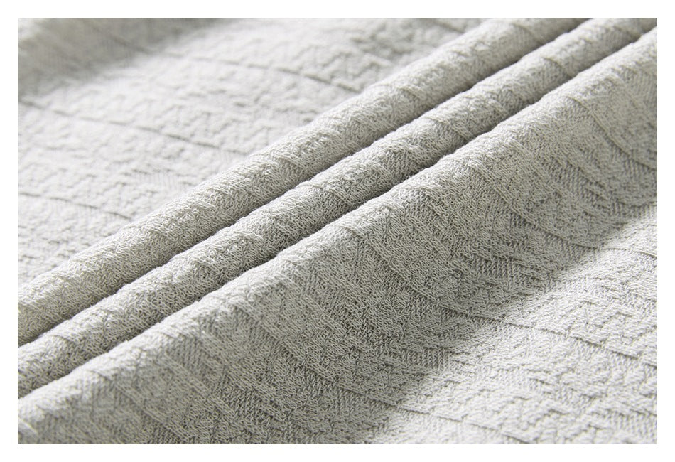 Close-up of light gray fabric with a raised geometric stripe pattern.