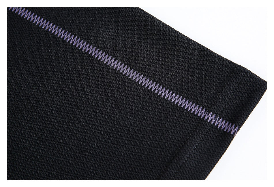Close-up of black textured fabric with a diagonal line of pale purple zigzag stitching.