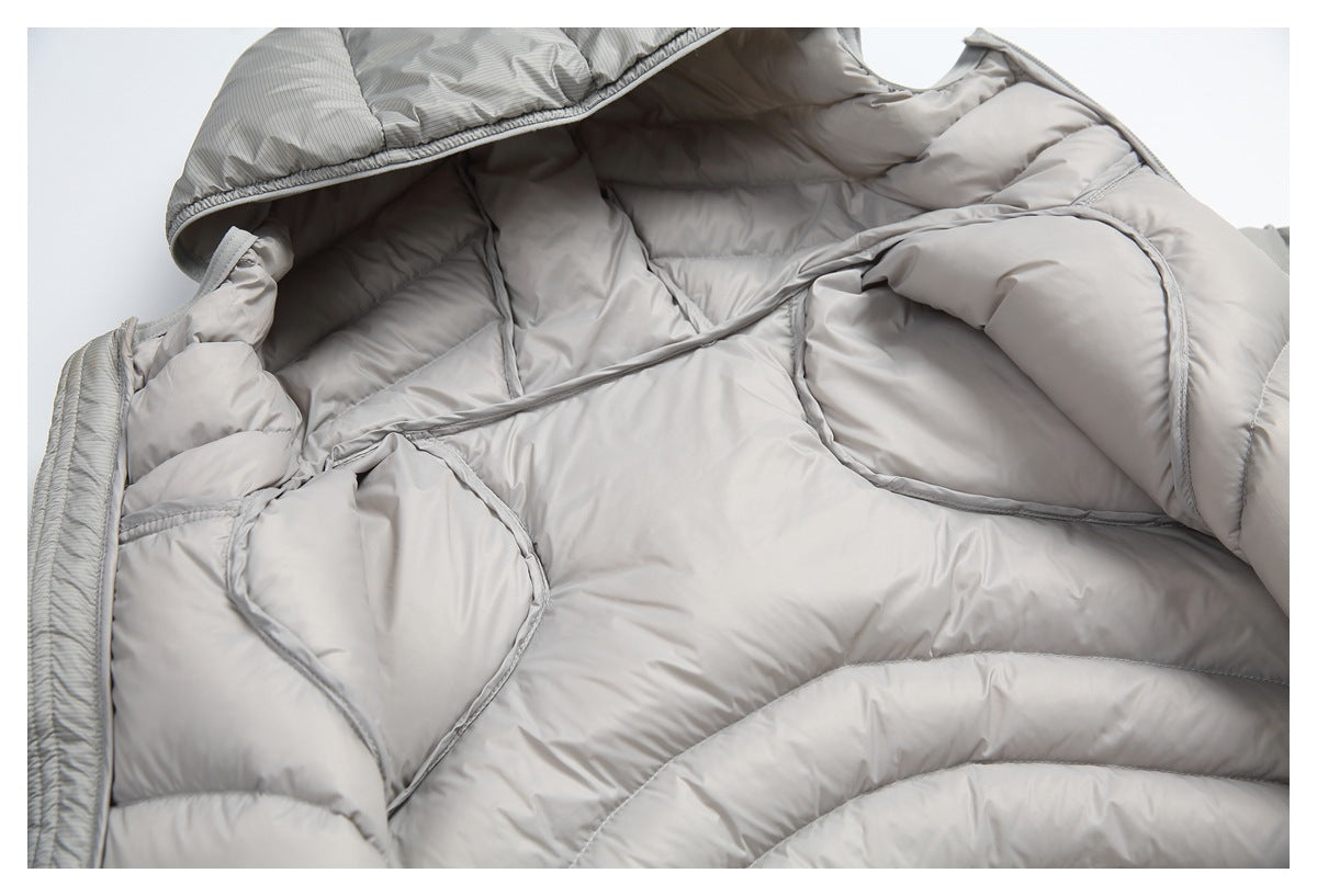 Close-up of the light gray puffer jacket opened to show its padded interior and stitched panel seams.