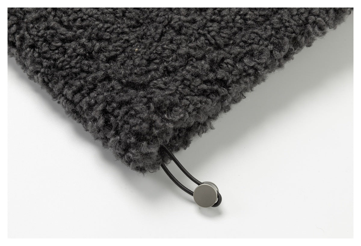 Close-up of charcoal loop-textured fabric with a black cord and round adjustment toggle.
