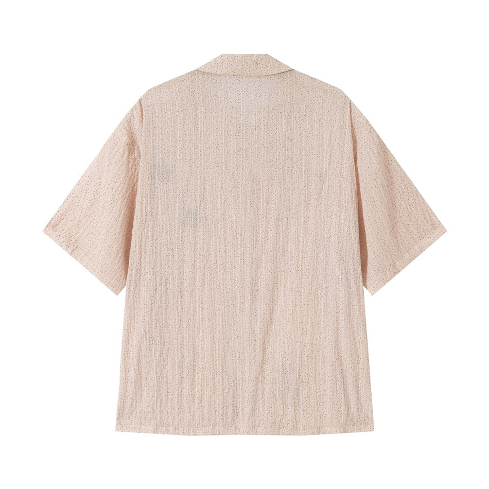 Back view of a washed pink short-sleeve shirt with crinkled texture and small dark dot print
