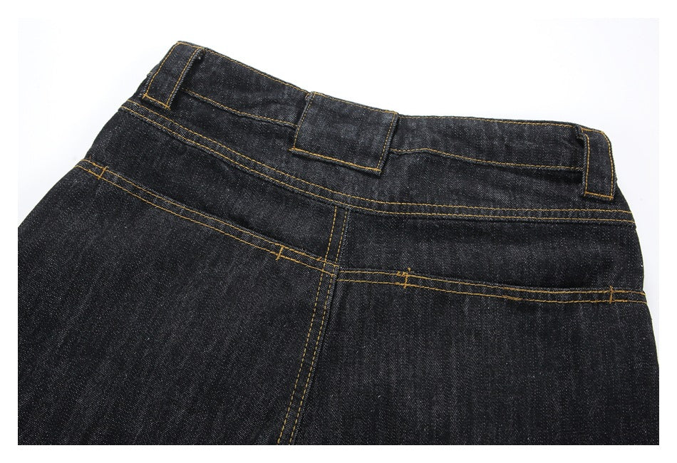 Back upper section of black denim trousers, showing the waistband, belt loops and golden stitching.