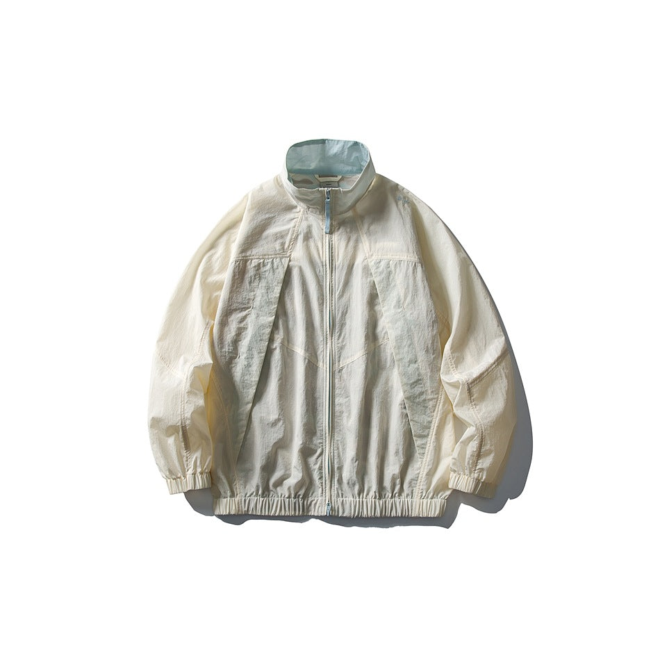 Sand white zip-up stand-collar jacket with gray-green paneling and a light blue inner collar