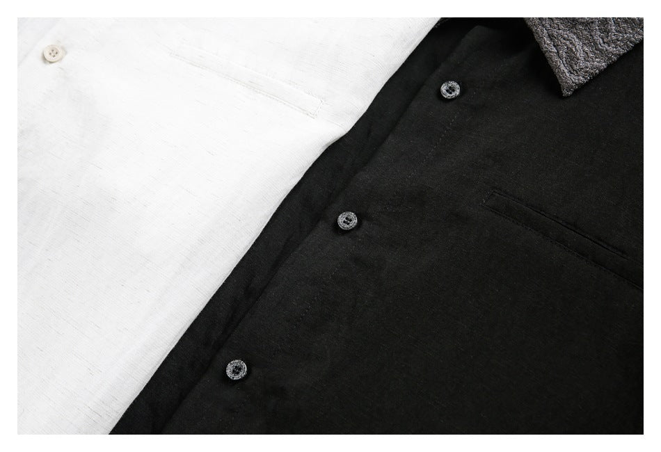 Close-up of white and black shirt fronts showing buttons, chest pockets, and textured collar fabric.