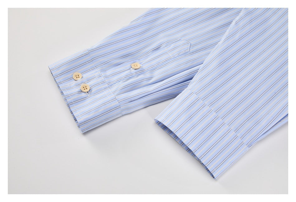 Close-up of two striped light blue shirt cuffs with beige buttons.