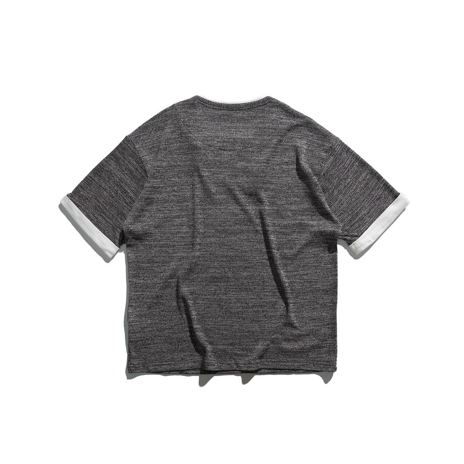 Back view of black heathered short-sleeve tee with plain back and white turned-back cuffs, flat lay