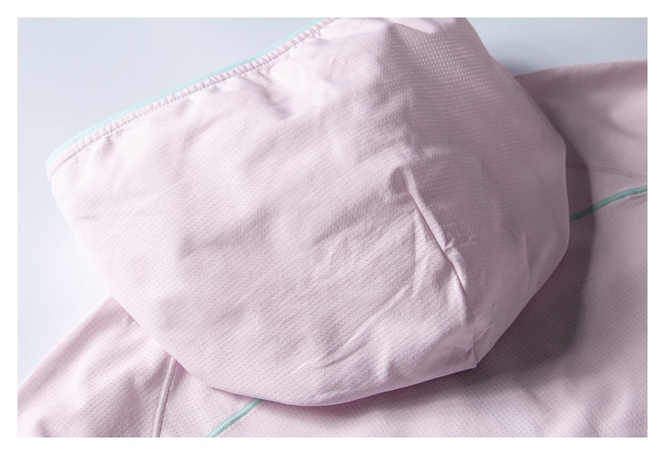Close-up of a pale pink garment hood or folded panel with mint-green edge piping and perforated fabric.