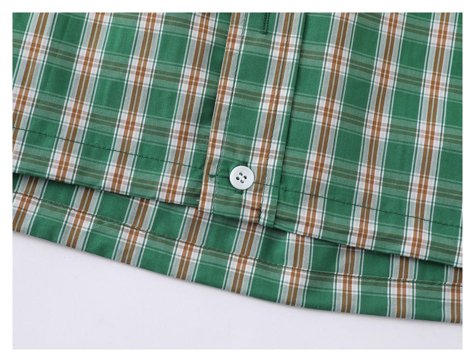 Close-up of the plaid shirt's buttoned front placket and stitched hem.