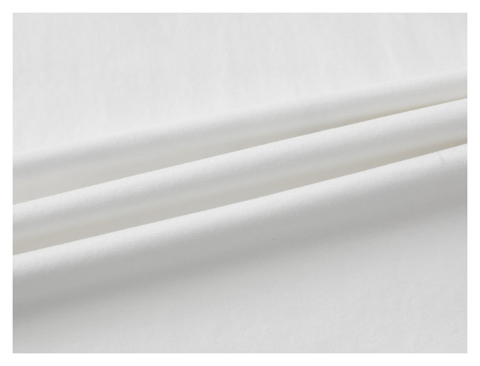 Close-up of white fabric arranged in folds, showing its surface texture.