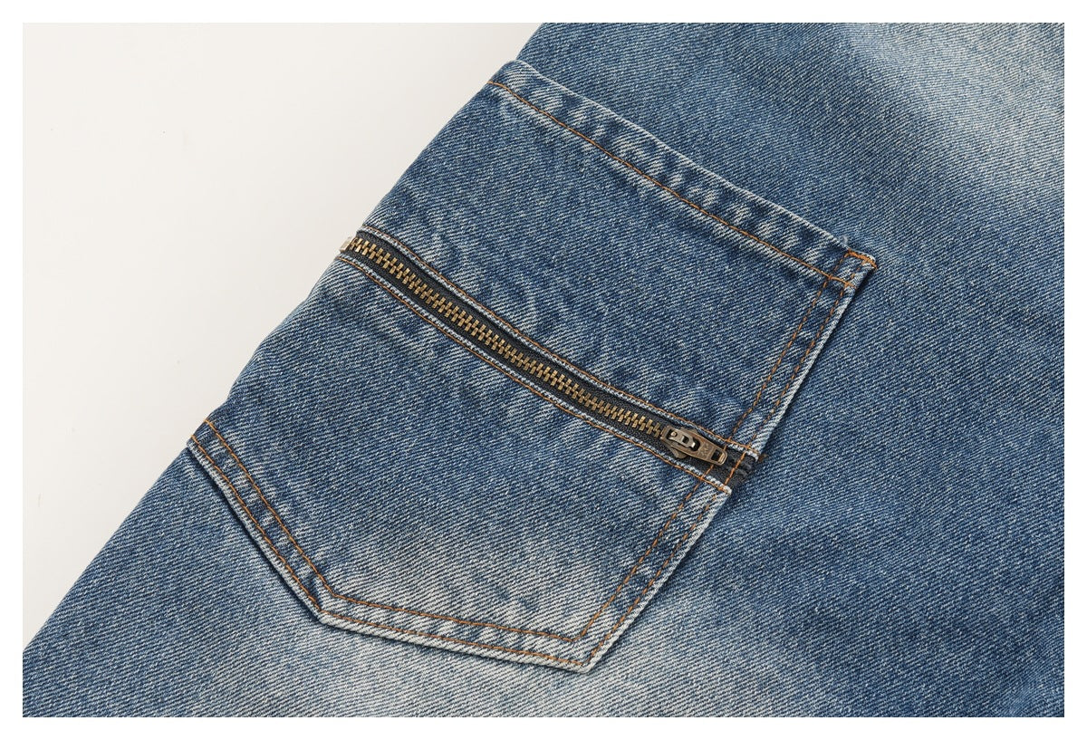 Close-up of a blue denim pocket with a horizontal metal zipper.