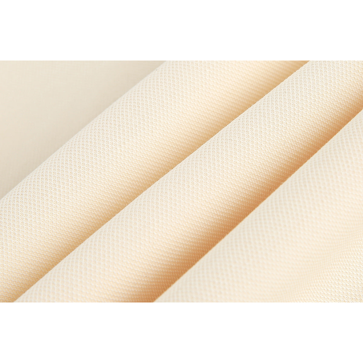 Macro view of the textured surface and folds of cream-colored garment fabric.