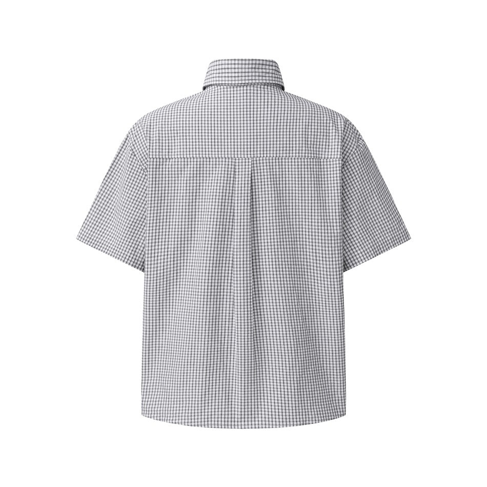 Back of a short-sleeve gingham check shirt showing the back yoke and center pleat on a white background