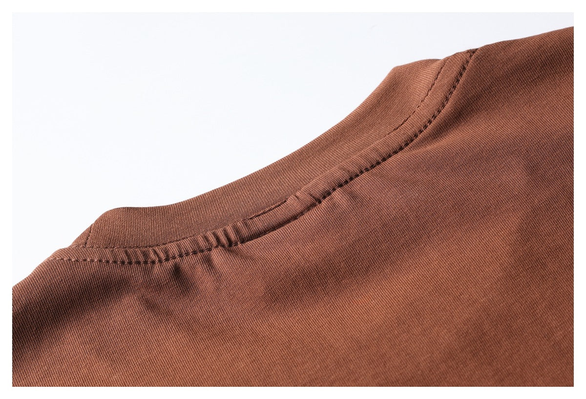 Close-up of the stitched neckline and shoulder seam on a rust-brown garment.