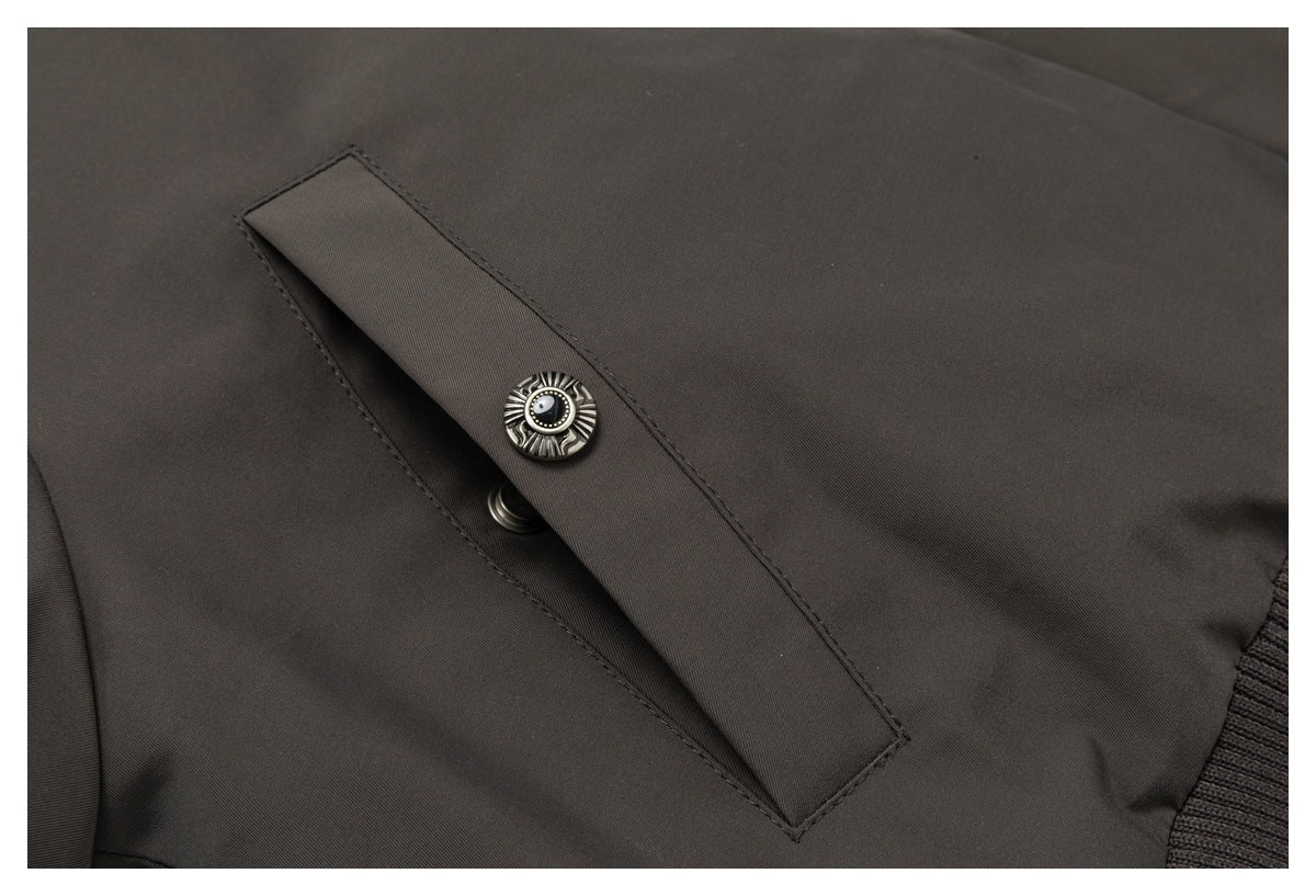 Close-up of a snap-fastened flap on a dark charcoal-brown jacket.