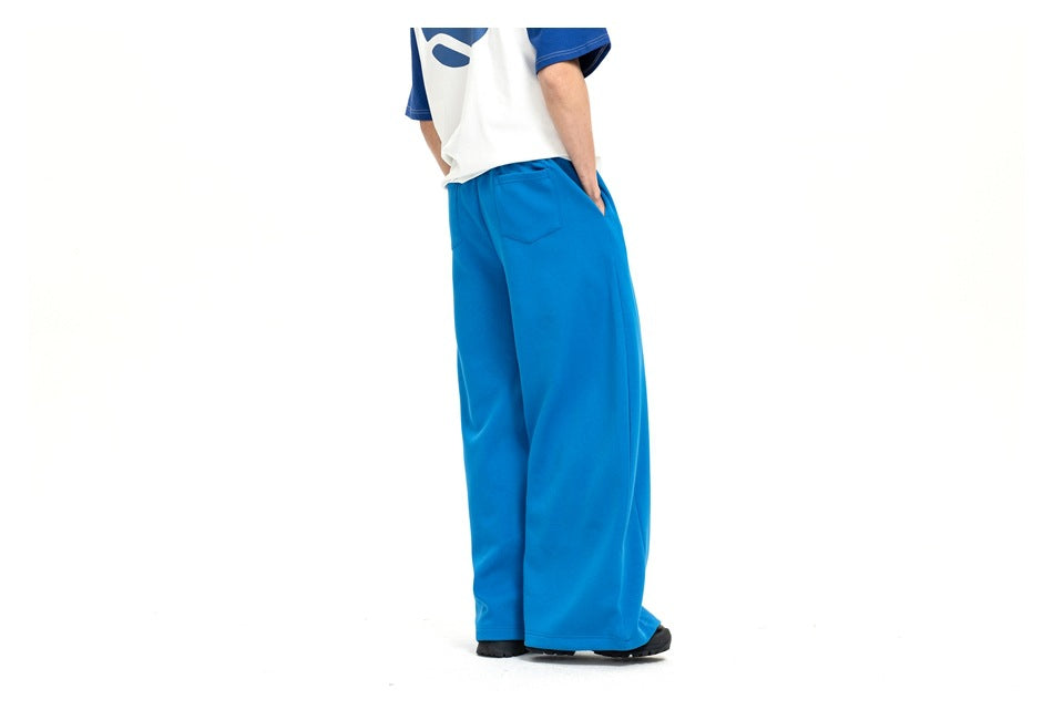 Model wearing bright blue wide-leg pants, shown from the back with a single rear pocket.