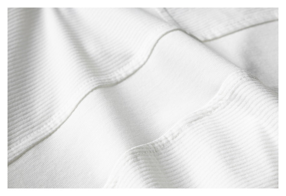Close-up of white ribbed knit fabric with curved seam stitching.
