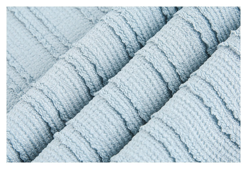 Extreme close-up of pale blue textured fabric gathered into soft folds.