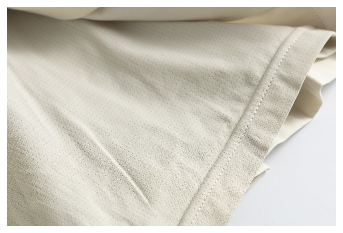 Close-up of the cream garment's finely textured inner fabric and stitched edge.