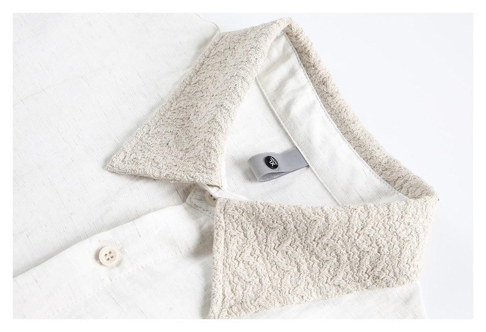 Close-up of an off-white shirt with a wide, textured contrasting collar and front buttons.