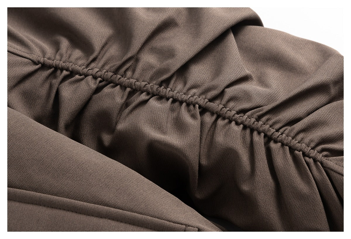 Close-up of the brown jacket's gathered elastic seam and textured fabric.