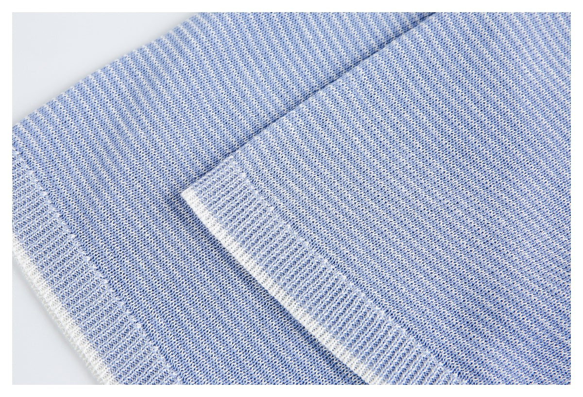Close-up of a blue-and-white heathered knit garment with a ribbed edge and seam.