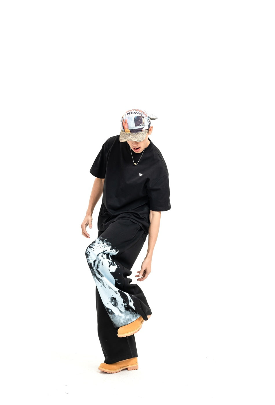 Model wearing black wide-leg pants with a large white horse graphic on one leg and a loose black T-shirt.