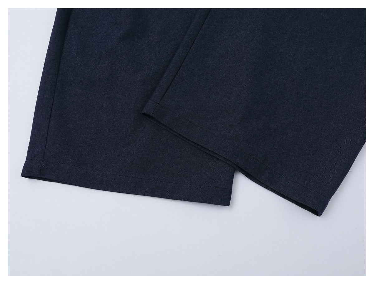 Close-up of the straight hems on dark navy trouser legs.