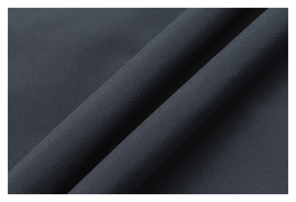Close-up of dark charcoal fabric folded to show its fine, tightly woven surface.