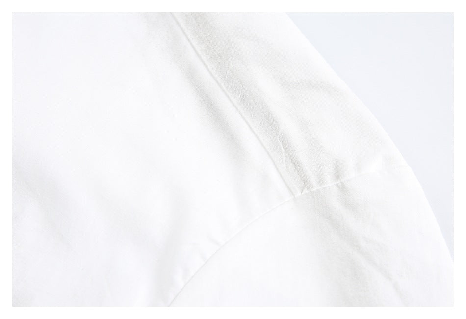 Close-up of intersecting seams on a white garment.