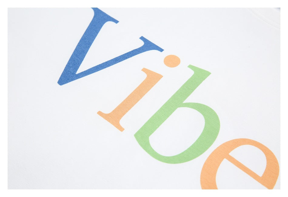 Close-up of large blue, orange, and green letters printed on white fabric.