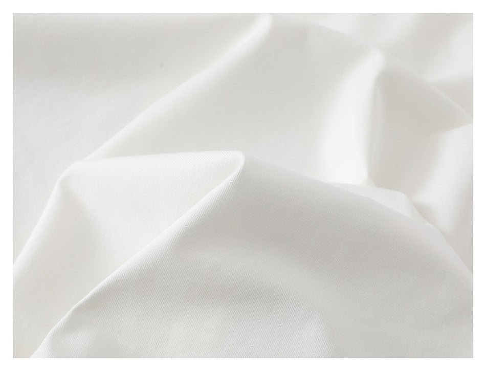 Close-up of smooth white fabric draped in soft folds.
