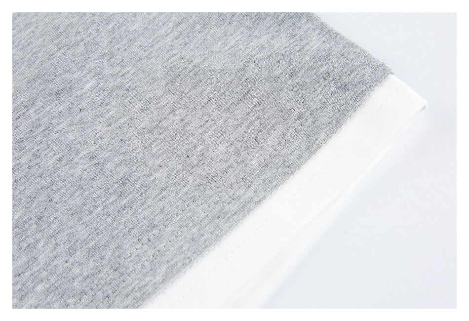 Close-up of heather-gray knit fabric beside a white edge with visible stitching.