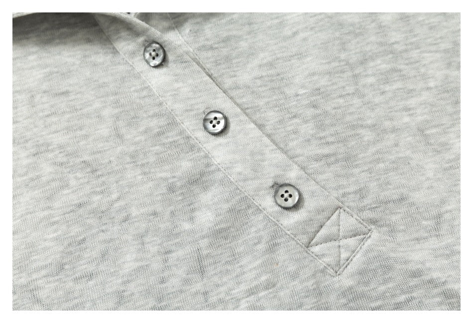 Close-up of a heather-gray knit garment with three gray buttons on a diagonal placket.