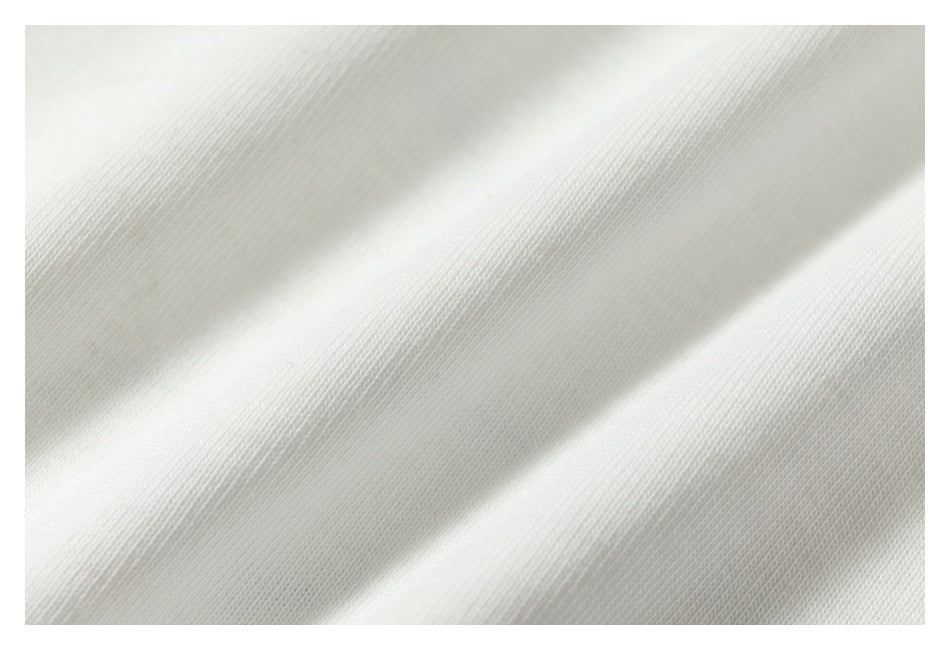 Close-up of pale fabric with a fine knit texture and soft diagonal folds.