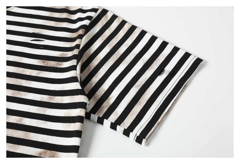 Close-up of a black-and-white striped sleeve cuff with a small dark button.
