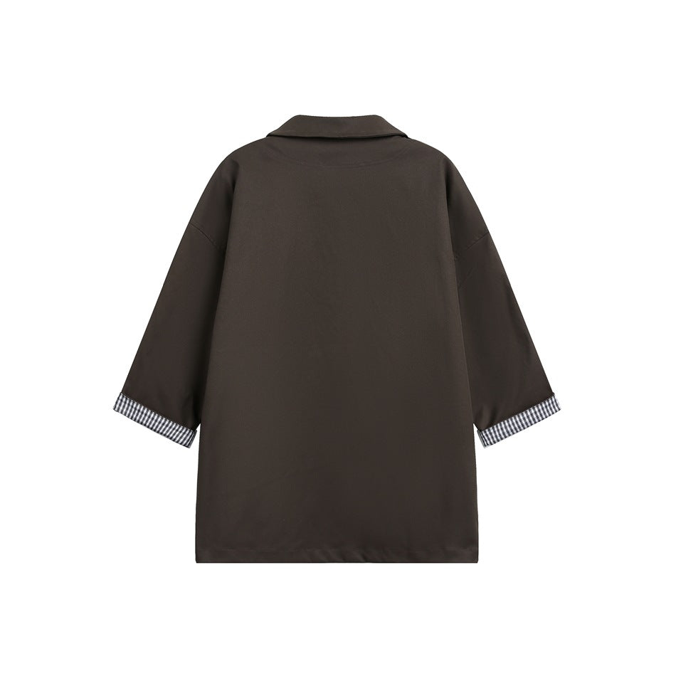 Back view of brown shirt with solid back, collar, drop shoulders and gingham rolled cuffs, flat lay
