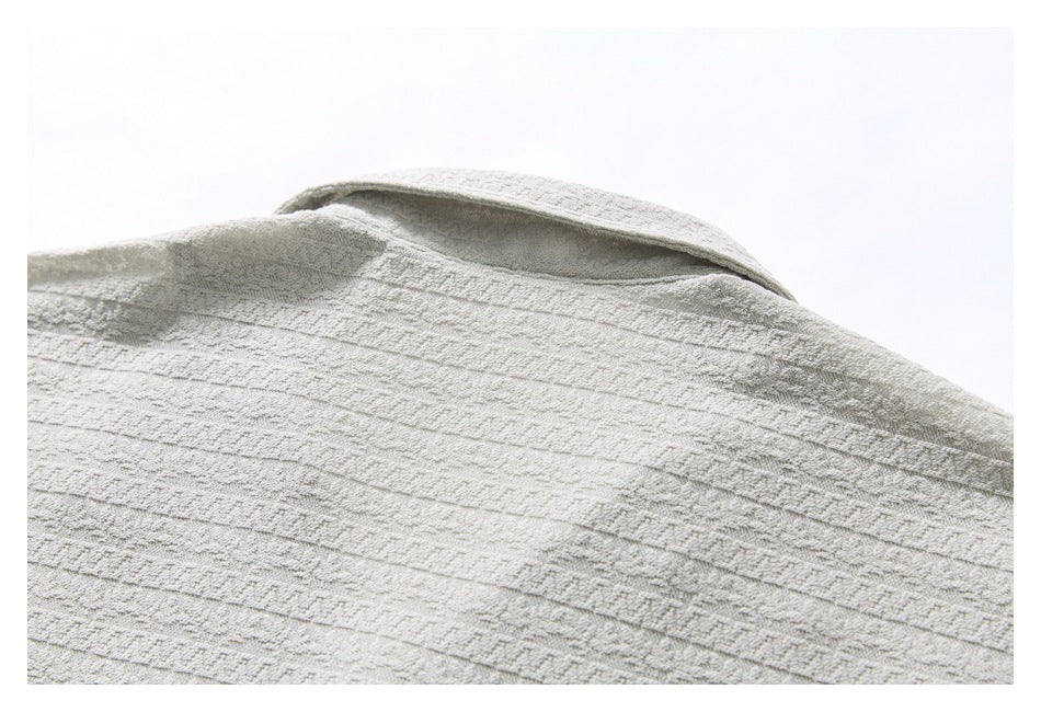 Close-up of the upper back and collar of a light gray shirt, showing its textured horizontal stripe pattern.