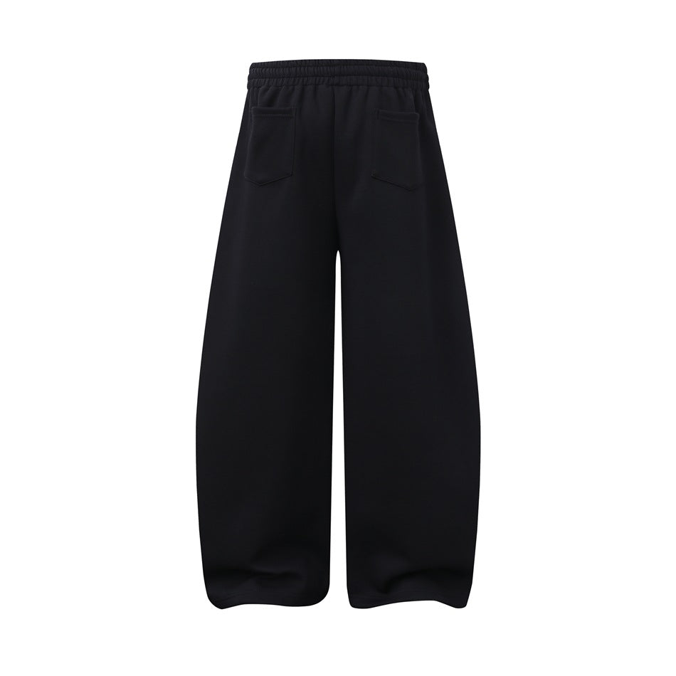 Black wide-leg pants shown flat from the back, with an elastic waistband and two rear patch pockets.