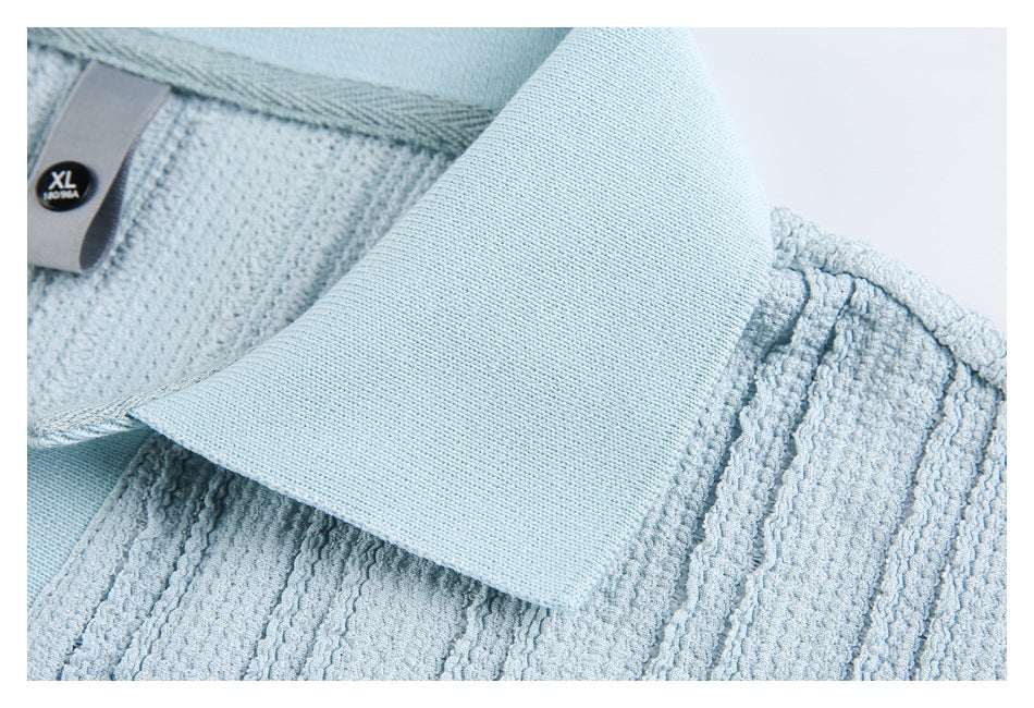 Close-up showing the pale blue polo shirt's broad collar and textured knit.