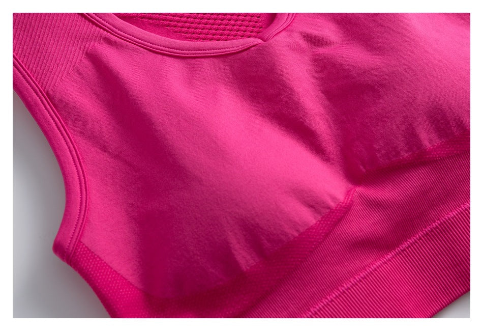 Close-up of a bright pink athletic top's front panel and wide ribbed lower band.