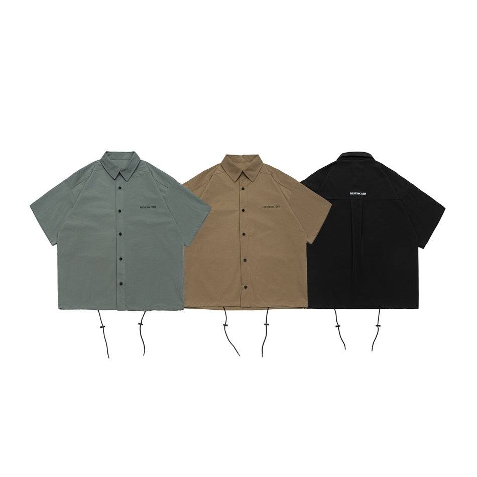 Gray-green, tan, and black short-sleeve button-up shirts shown from the front, with collars and dangling hem cords.