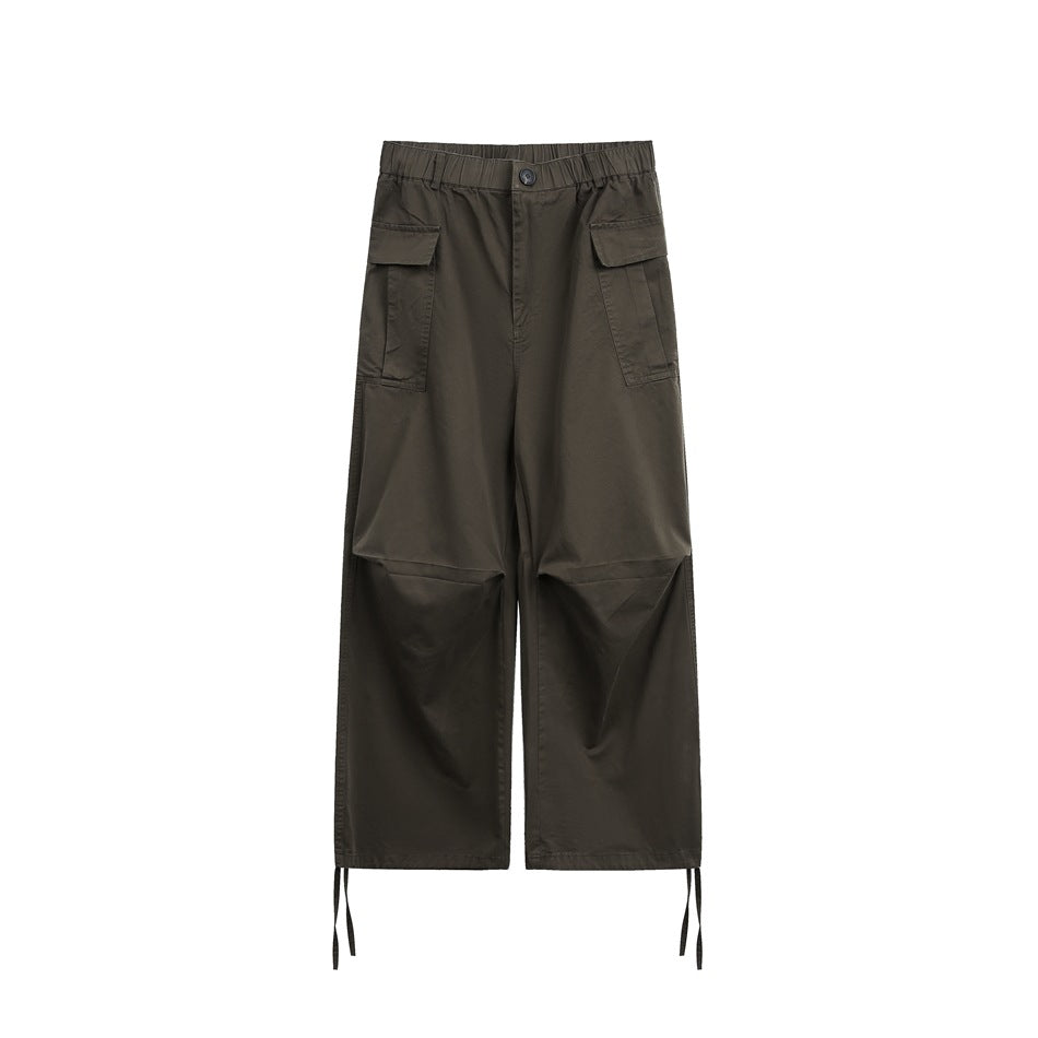 Dark gray wide-leg cargo pants flat lay, front view with button, flap cargo pockets, knee pleats and hem ties