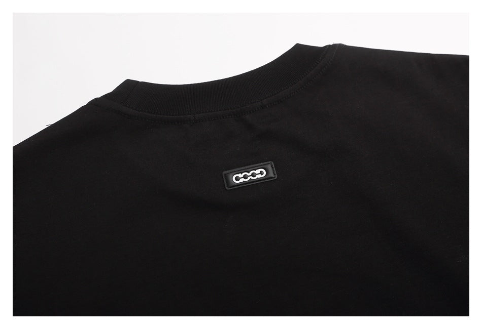 Close-up of the back neckline of a black T-shirt with a small rectangular logo badge.