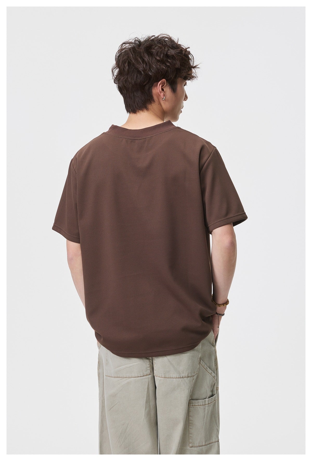Back view of a model wearing a plain brown short-sleeve T-shirt.