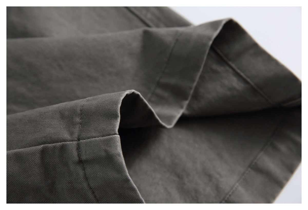 Close-up of charcoal-gray trouser hems folded over to show the inside and edge stitching.