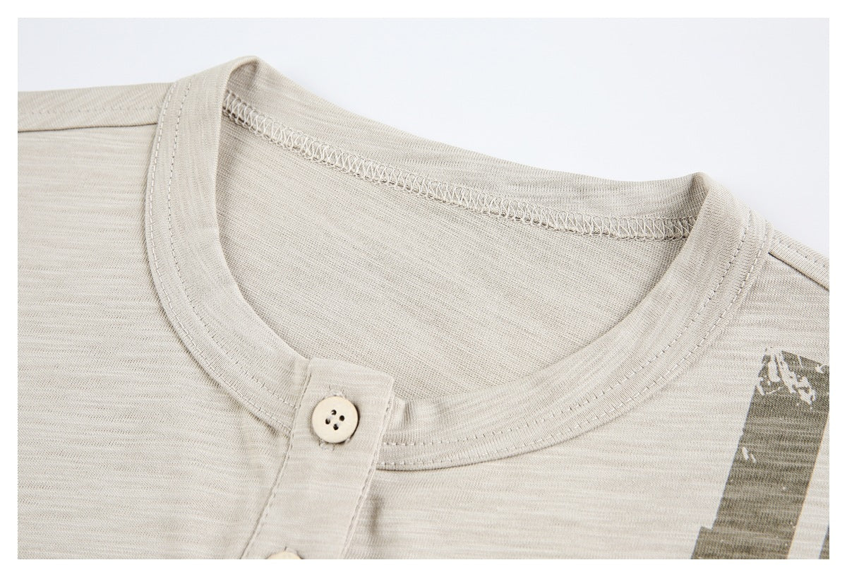 Close-up of a cream shirt’s round neckline, stitching, and single-button placket.